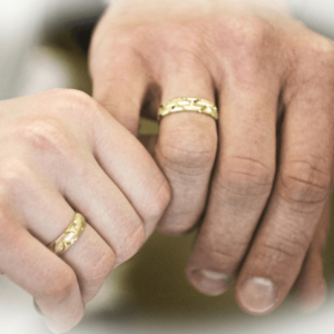 Couple holding hands wearing wedding rings