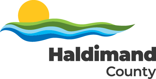 Haldimand County logo. A yellow sun rising or setting atop green and blue waves. Haldimand County is in black text below, slightly offset from centre.